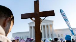 An anti-abortion protester holds a cross while demonstrating in front of the US Supreme Court in Washington, DC, on December 1, 2021.