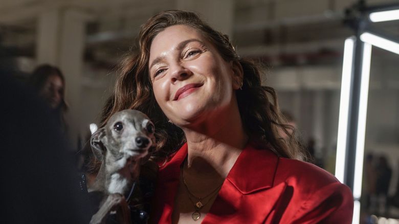 Drew Barrymore holds her dog during an interview before viewing Christian Siriano's fall/winter 2022 fashion collection, Saturday Feb. 12, 2022, in New York.