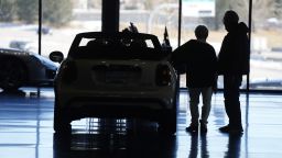 In this Friday, Feb. 18, 2022, photograph, a buyers consider a 2022 Cooper convertible on display in a Mini dealership in Highlands Ranch, Colo.