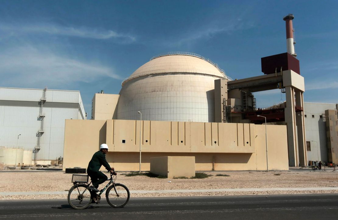 A worker rides past the reactor building of the Bushehr nuclear power plant, just outside the southern city of Bushehr, Iran, in 2010.