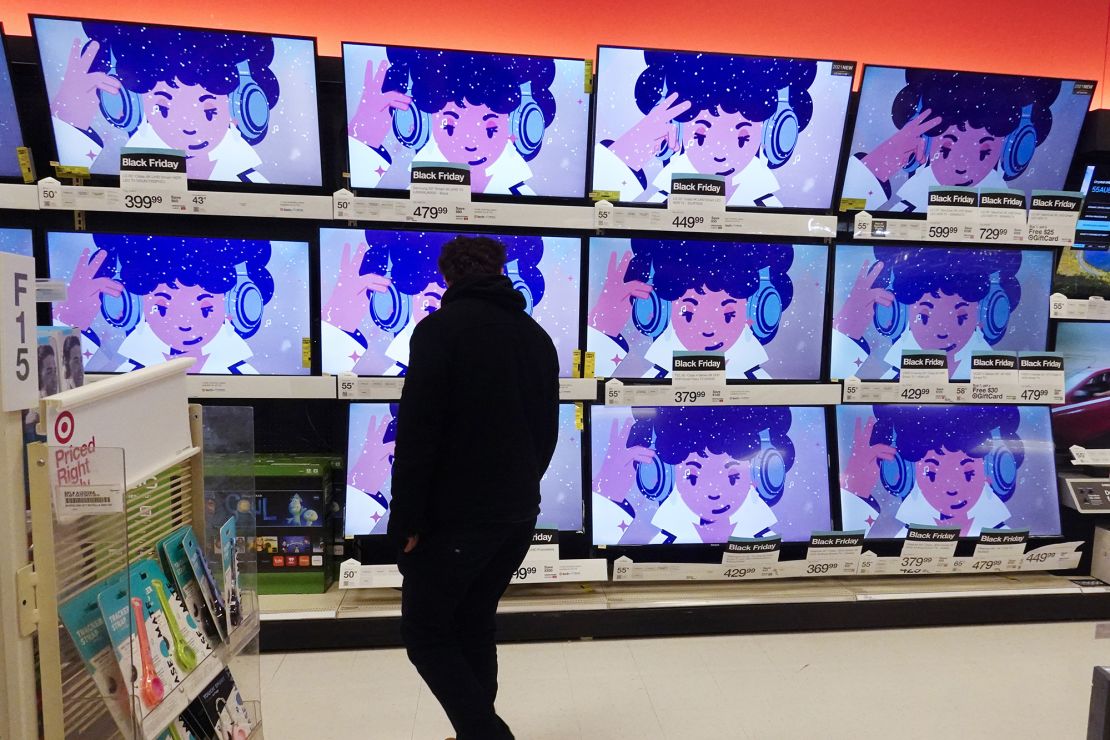 A shopper looks at televisions in a store in Indianapolis on Friday, Nov. 26, 2021.