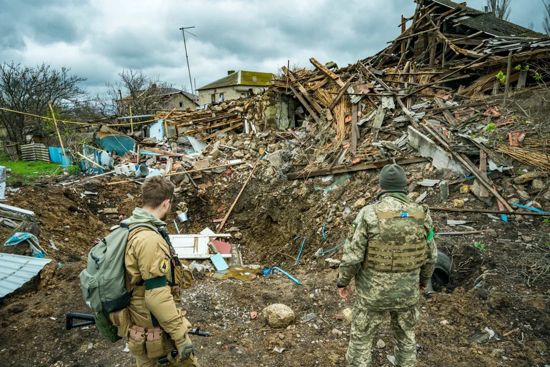 Soldados observan los restos de una casa destruida en el pueblo de Shevchenkove, región de Mikolayv, Ucrania, en abril de 2022.