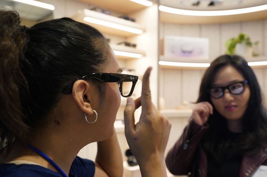 A Meta experience expert, left, demonstrates the Ray-Ban Stories smart glasses in Burlingame, California, on May 4, 2022.