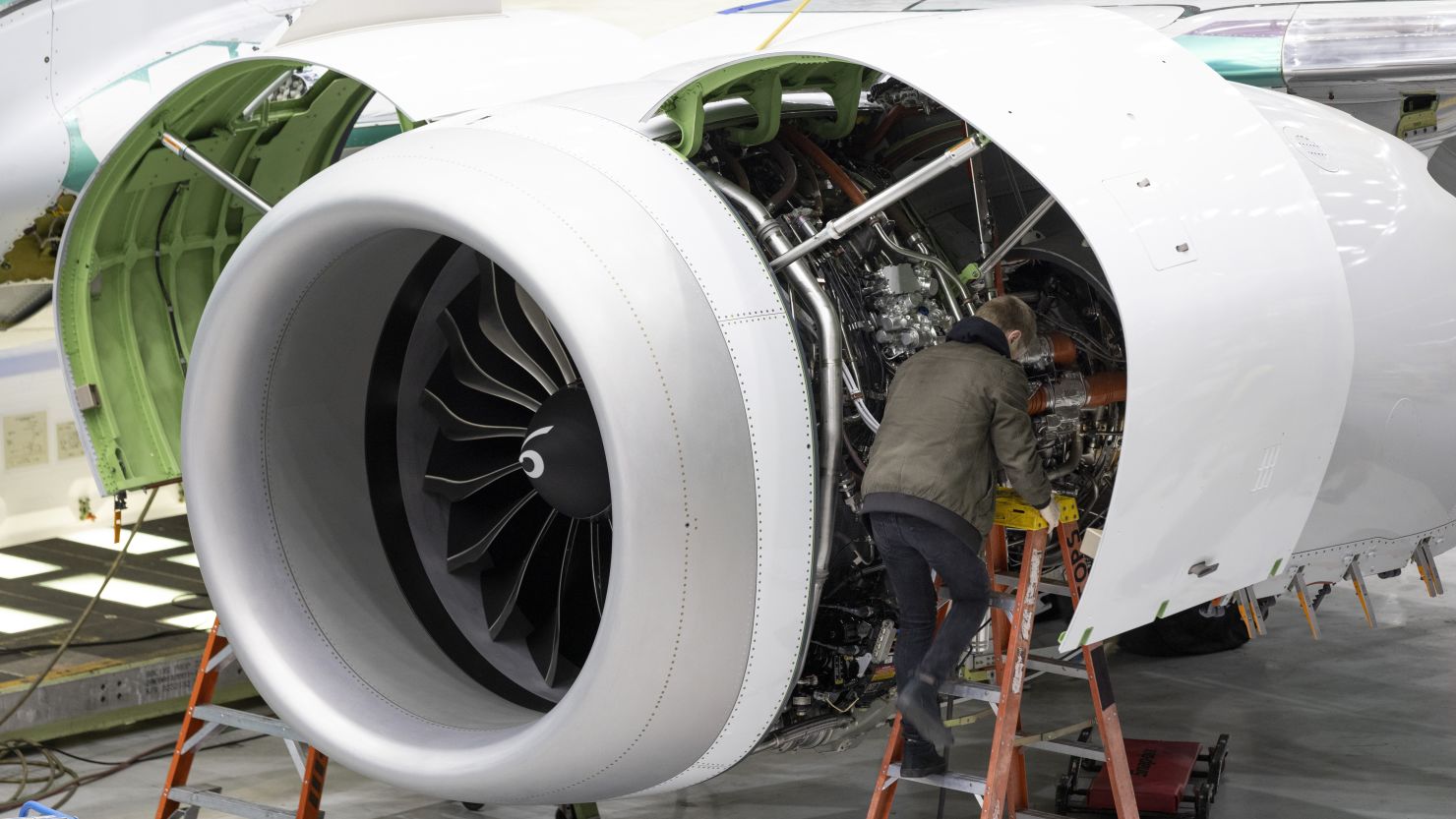 A Boeing employee works on the engine of a 737 MAX on the final assembly line at Boeing's Renton plant.