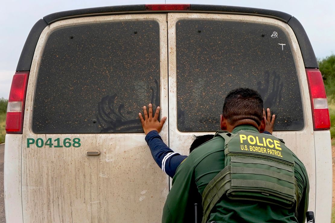 A migrant is searched  after being apprehended by US Border Patrol agents near Sasabe, Arizona, in 2022.