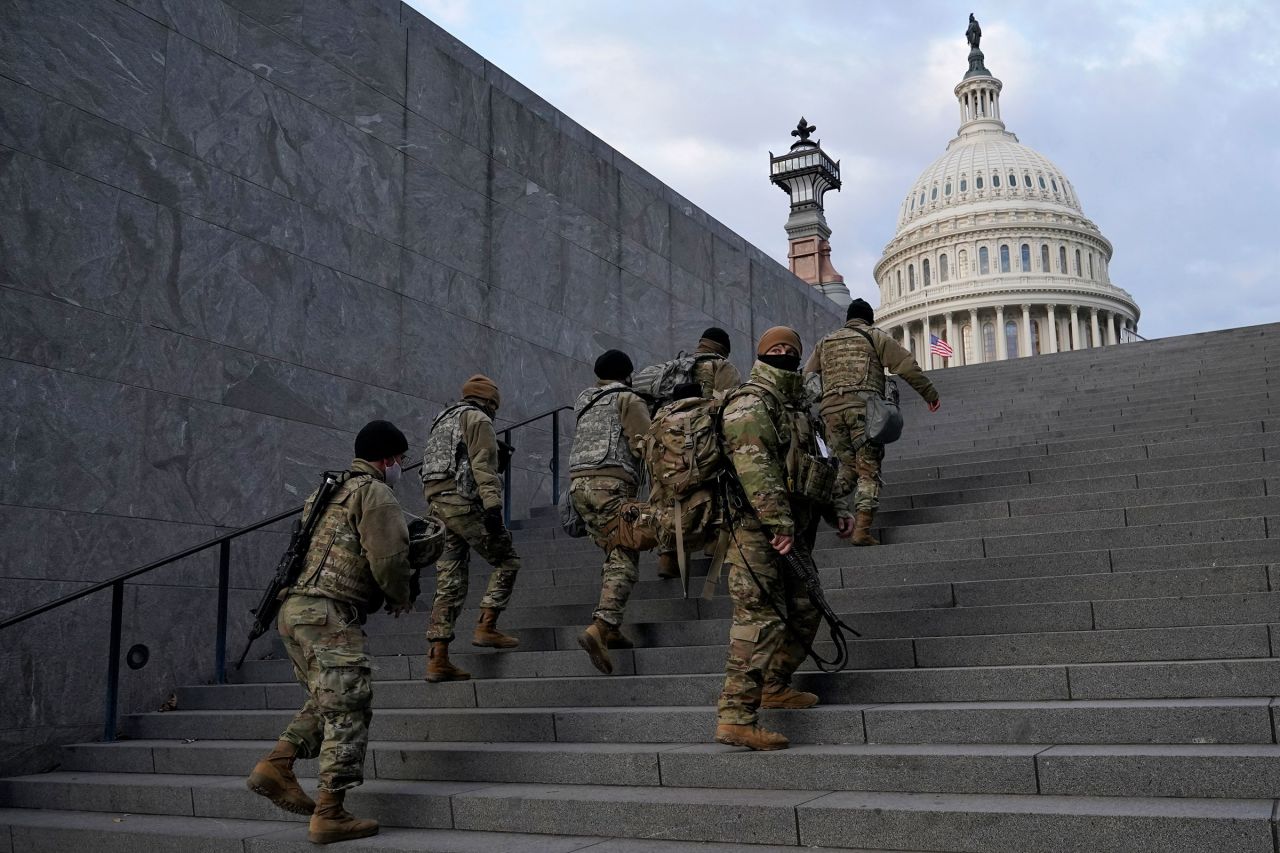 National Guard members walk toward the US Capitol building before a rehearsal for Joe Biden's Presidential Inauguration in 2021.