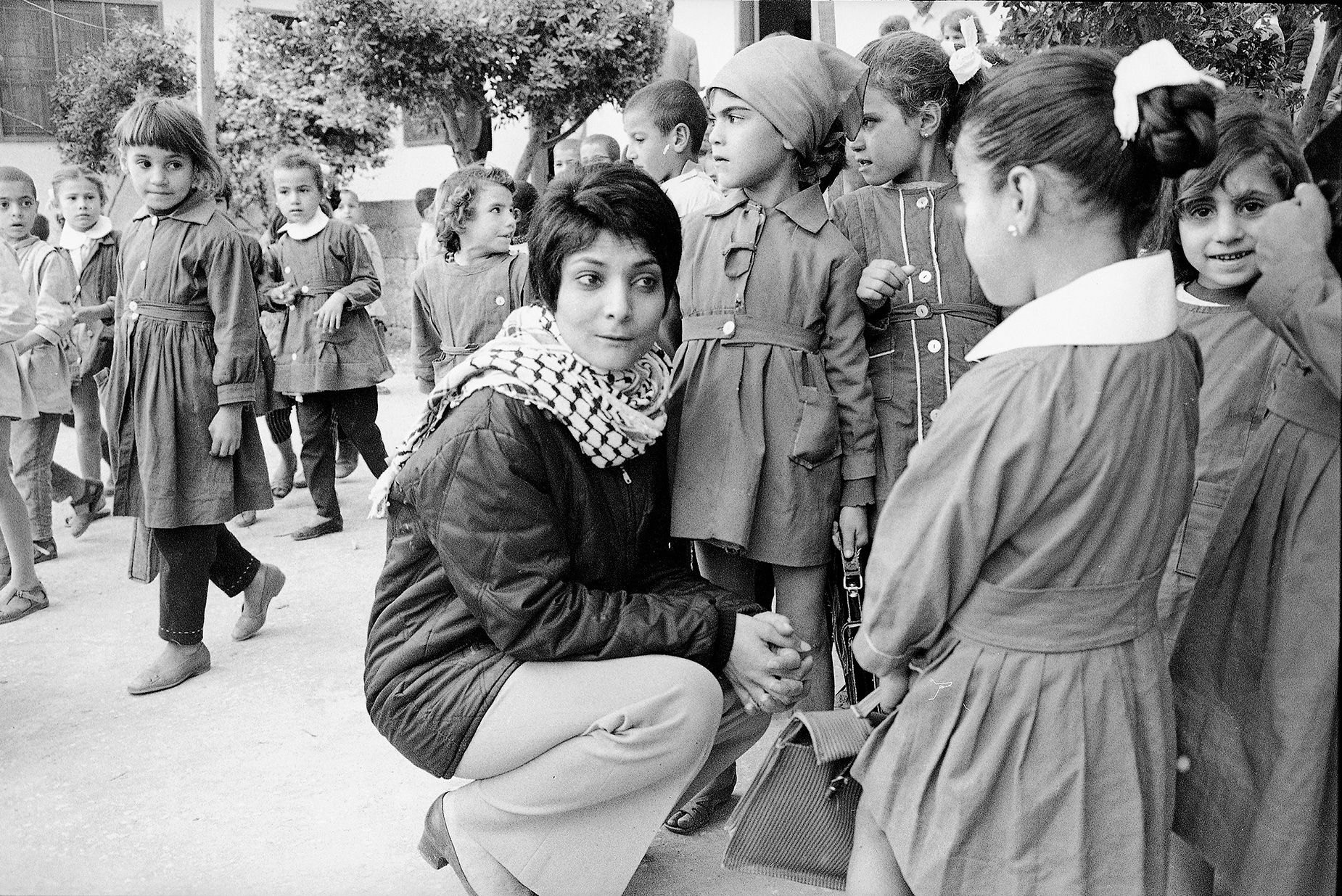 Leila Khaled wears a keffiyeh while visiting a Palestinian refugee camp in 1970.