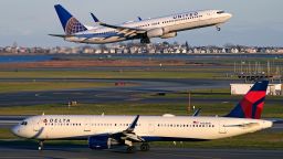 A United Airlines jet takes off while a Delta Airlines plane taxis at Logan International Airport, Monday, Nov. 21, 2022, in Boston. Travel experts say the ability of many people to work remotely is letting them take off early for Thanksgiving or return home later. Crowds are expected to rival those of 2019, the last Thanksgiving before the pandemic. (AP Photo/Charles Krupa)