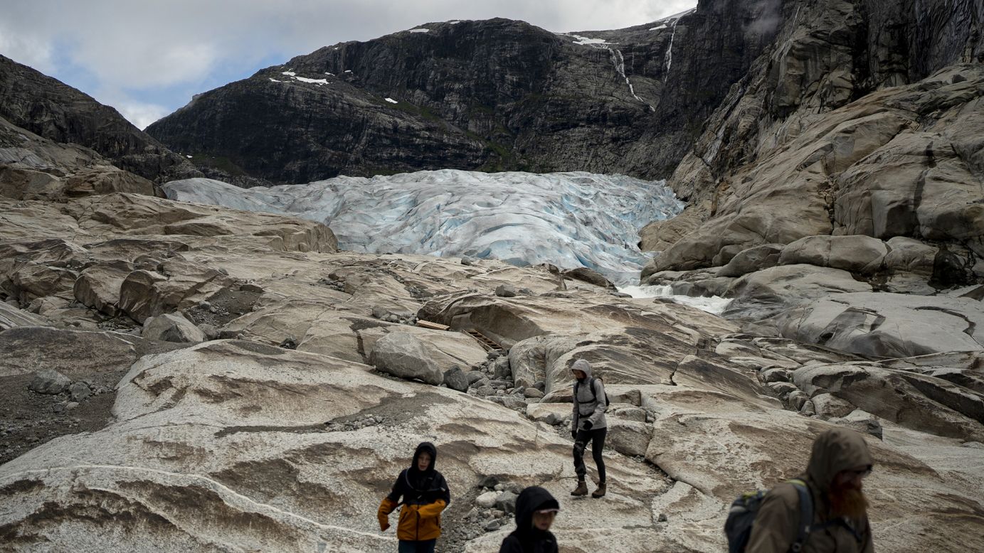 Tourists hike to visit the Nigardsbreen glacier in Jostedal, Norway in August 2022.