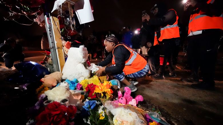 Sierra Rogers, who called Tyre Nichols her best friend, adjusts items in a memorial, after a prayer gathering at the site where he was beaten by Memphis police officers, and later died from his injuries, in Memphis, Tenn., Monday, Jan. 30, 2023. (AP Photo/Gerald Herbert)