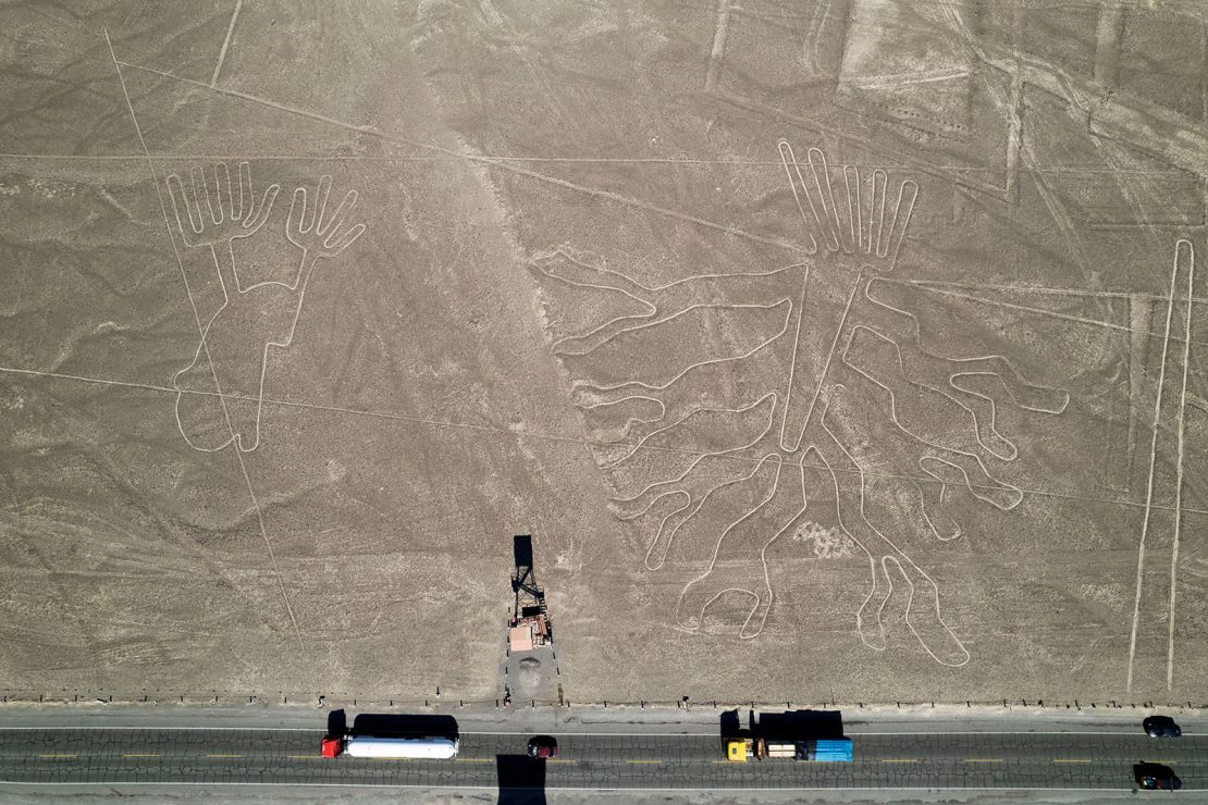 Trucks drive along the Pan American Highway past ancient geoglyphs known as the Nazca Lines in Peru on May 17, 2023.