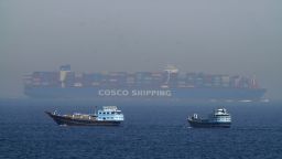 Two traditional dhows sail by a large container ship in the Strait of Hormuz Friday, May 19, 2023.