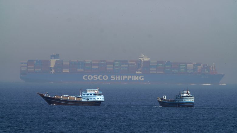 Two traditional dhows sail by a large container ship in the Strait of Hormuz Friday, May 19, 2023.