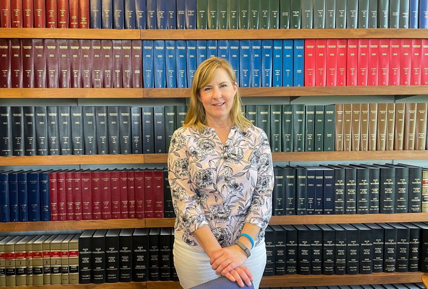 Melissa Hortman stands in her St. Paul office in front of a bookshelf filled with leather-bound books of Minnesota laws over the years in May 2023.