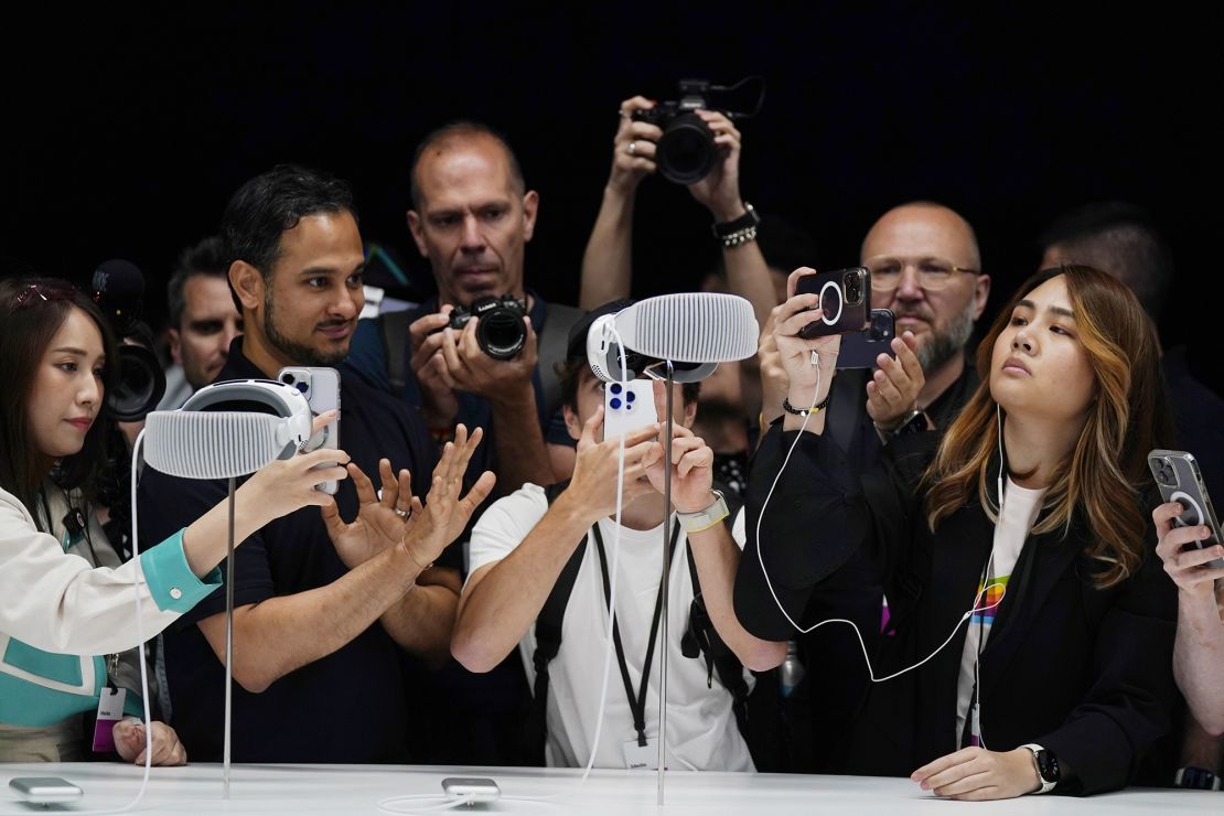 A crowd gathers around the Apple Vision Pro headset as it is displayed in a showroom on the Apple campus in Cupertino on June 5.