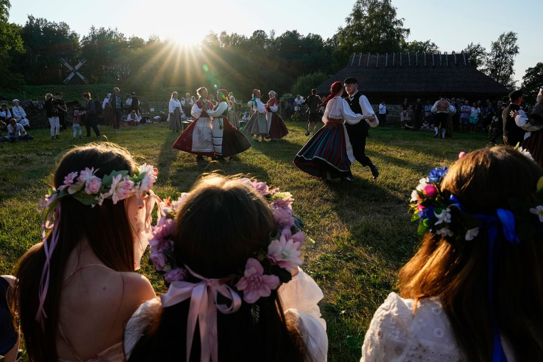 People dressed in traditional clothing dance during celebrations of Midsummer Day at the Open Air Museum in Tallinn, Estonia, on June 23, 2023.