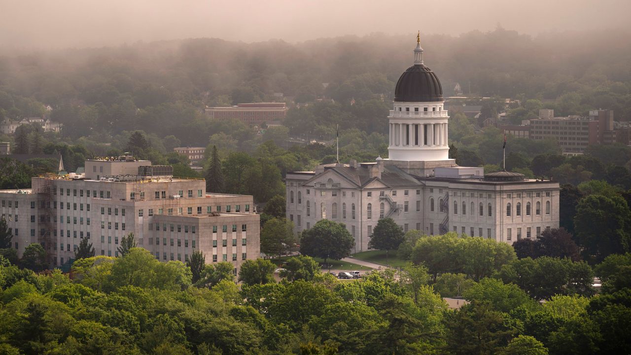 The morning fog lifts beyond the State House, right, in June in Augusta, Maine.