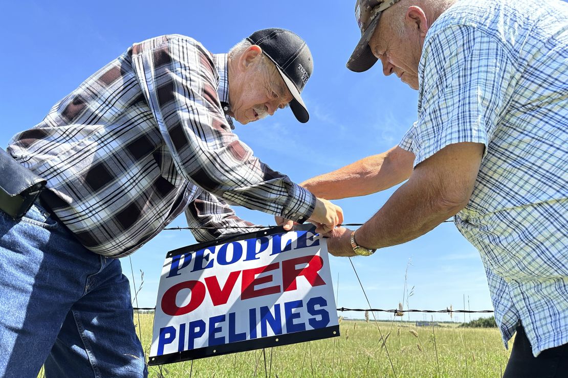 Gaylen Dewing and Marvin Abraham put up a sign opposing the Summit pipeline east of Bismarck, N.D. in August 2023.