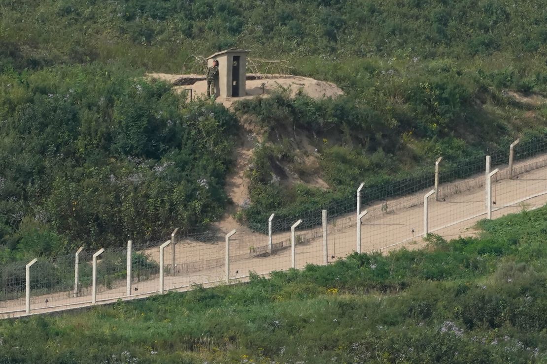 A North Korean soldier rests near a guard post along fences on the North Korea border with Russia and China seen from China's Yiyanwang Three Kingdoms viewing platform in Fangchuan in northeastern China's Jilin province on September 12, 2023.