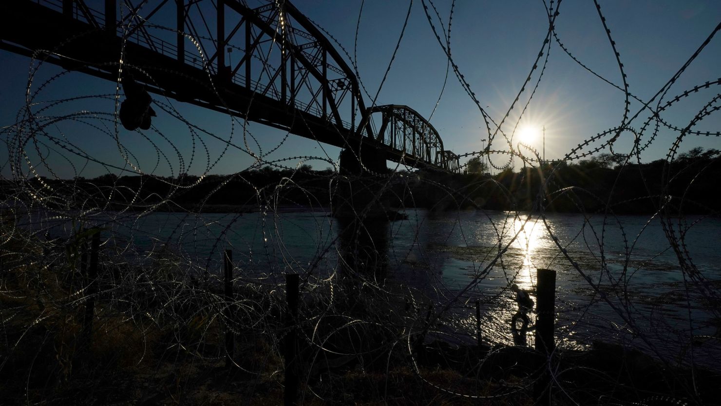 A migrant walks along the banks of the Rio Grande near the Union Pacific International Railroad Bridge in September in Eagle Pass, Texas. 