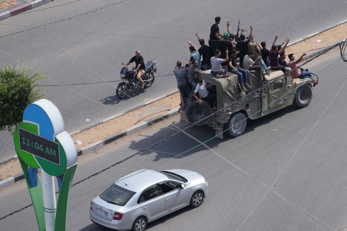 Palestinian militants drive a captured Israeli military vehicle in Gaza City on October 7, 2023, after the attacks on Israel.
