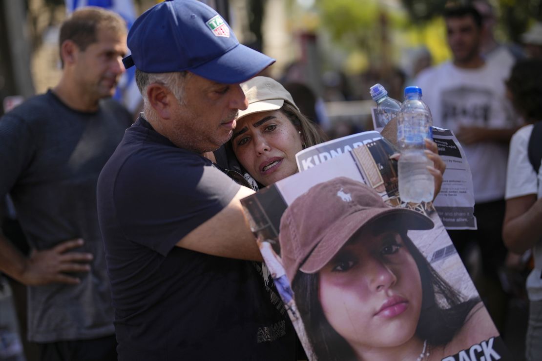 Shira and Eli Albag hold a photo of their daughter Liri, who was just 18 years old when Hamas attacked. Another hostage says Liri saved her life by talking to their captors.