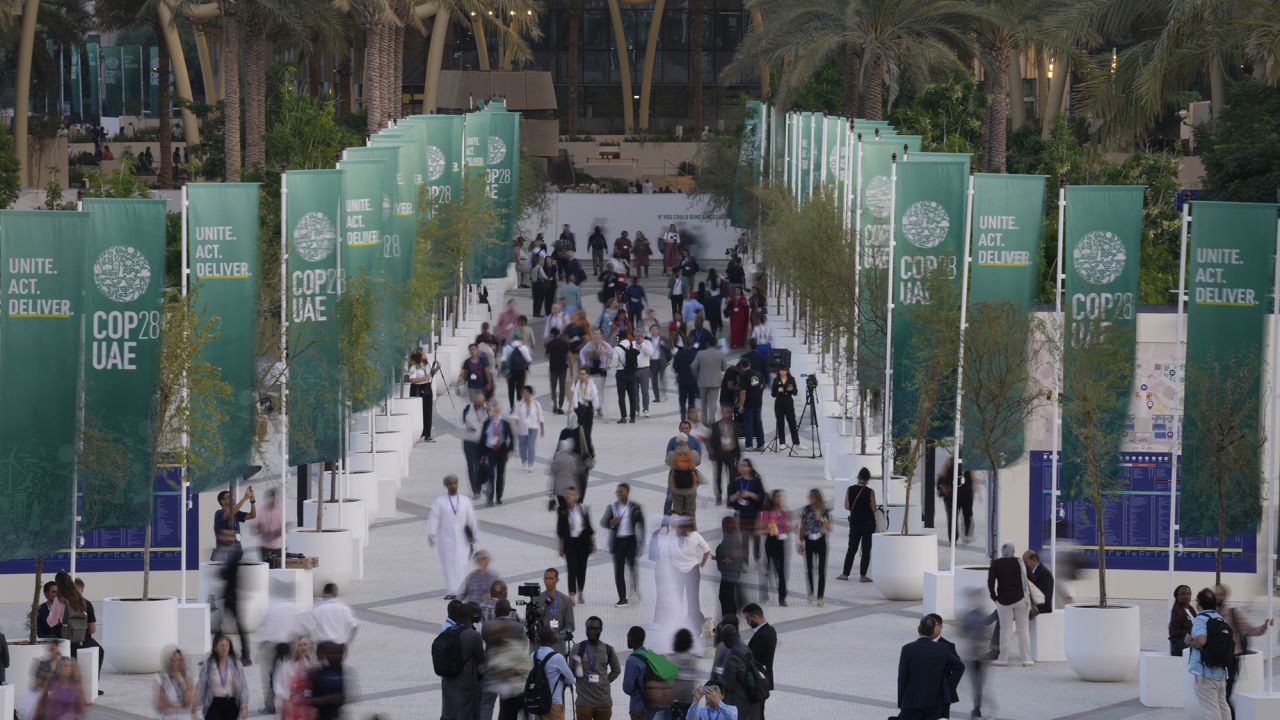People walk through the COP28 U.N. Climate Summit, Monday, Dec. 4, 2023, in Dubai, United Arab Emirates.