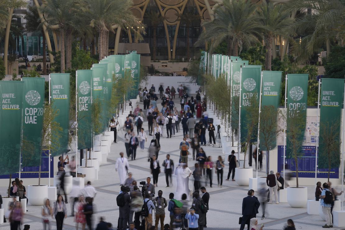 People walk through the COP28 U.N. Climate Summit, Monday, Dec. 4, 2023, in Dubai, United Arab Emirates.