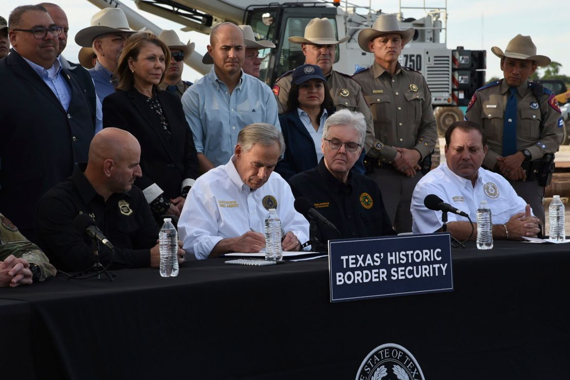 Gov. Greg Abbott signs three bills into law at a border wall construction site in Brownsville, Texas on Monday, Dec. 18, 2023, that will broaden his border security plans and add funding for more infrastructure to deter illegal immigration.