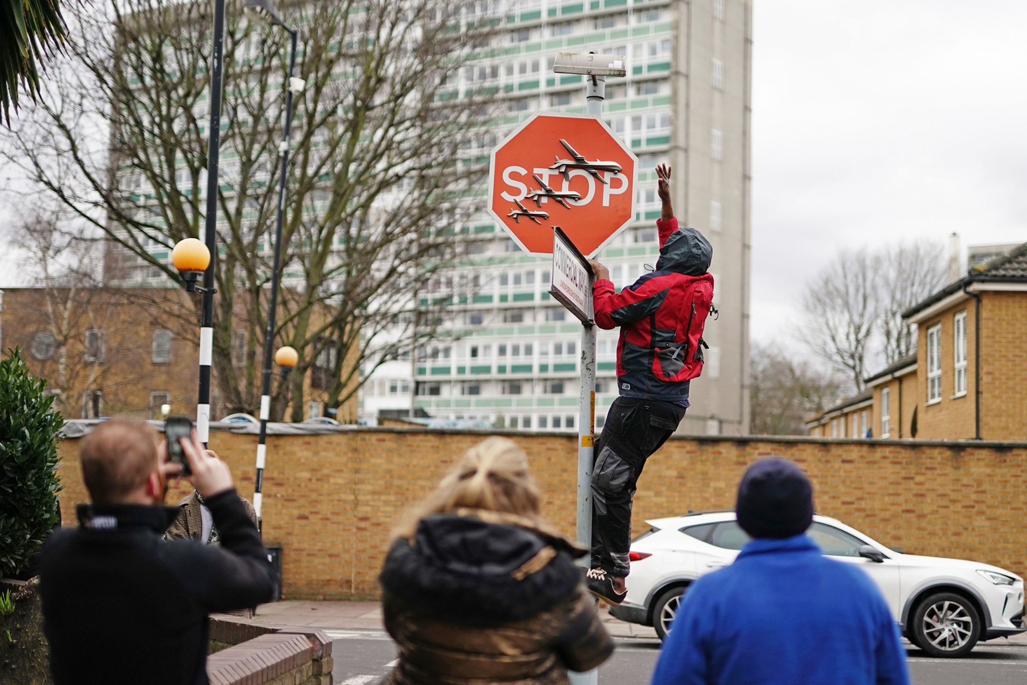 A man is pictured removing a Banksy artwork from a street in south London.
