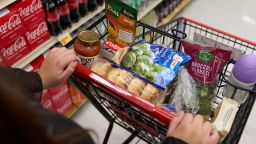 A food shopper pushes a cart of groceries at a supermarket in Bellflower, California, in February 2023.