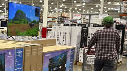 Shopper passes by display of big-screen televisions in a Costco warehouse Thursday, Jan. 11, 2024, in Sheridan, Colorado.