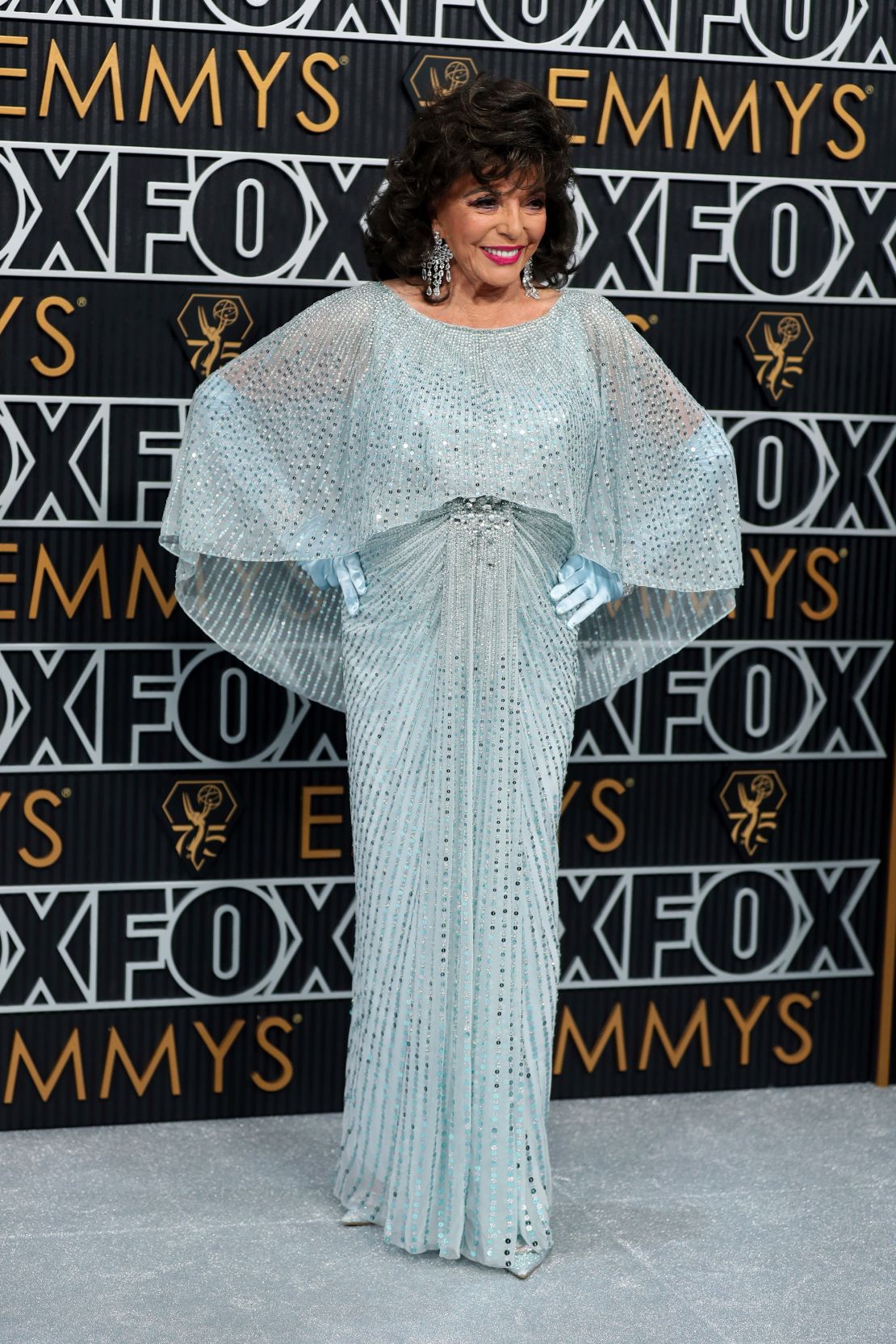 Joan Collins looked like she could have stepped off the set of a classic Hollywood movie in her Art Deco-inspired Jenny Packman sequined gown and matching opera gloves.