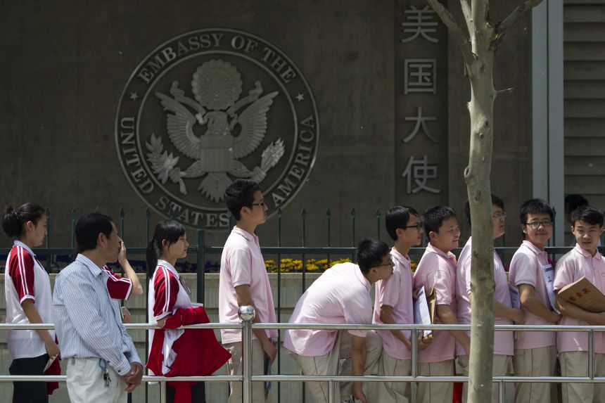 Chinese students are waiting outside the US Embassy for a visa application interview in Beijing on May 2, 2012.