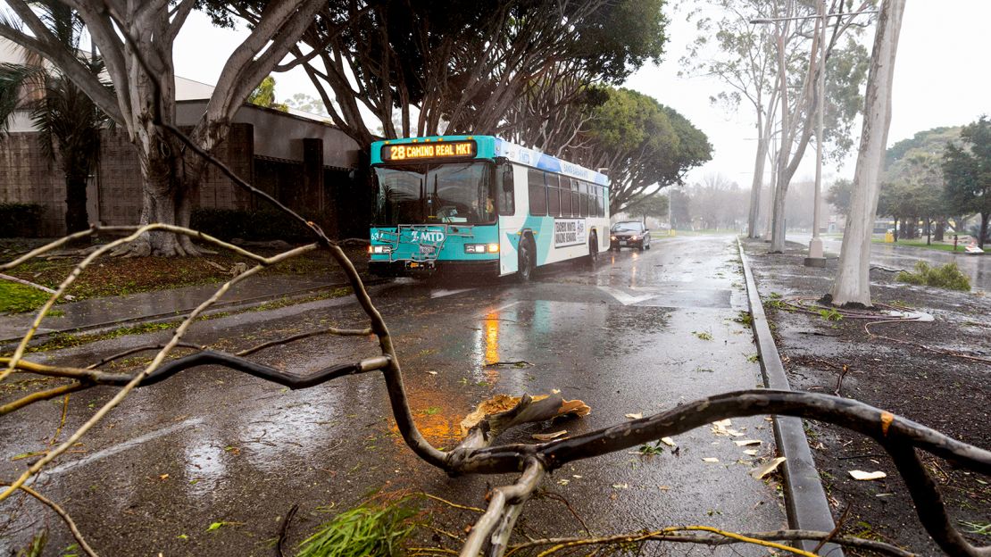 A vehicle passes over fallen branches during a rainstorm in Goleta, California.