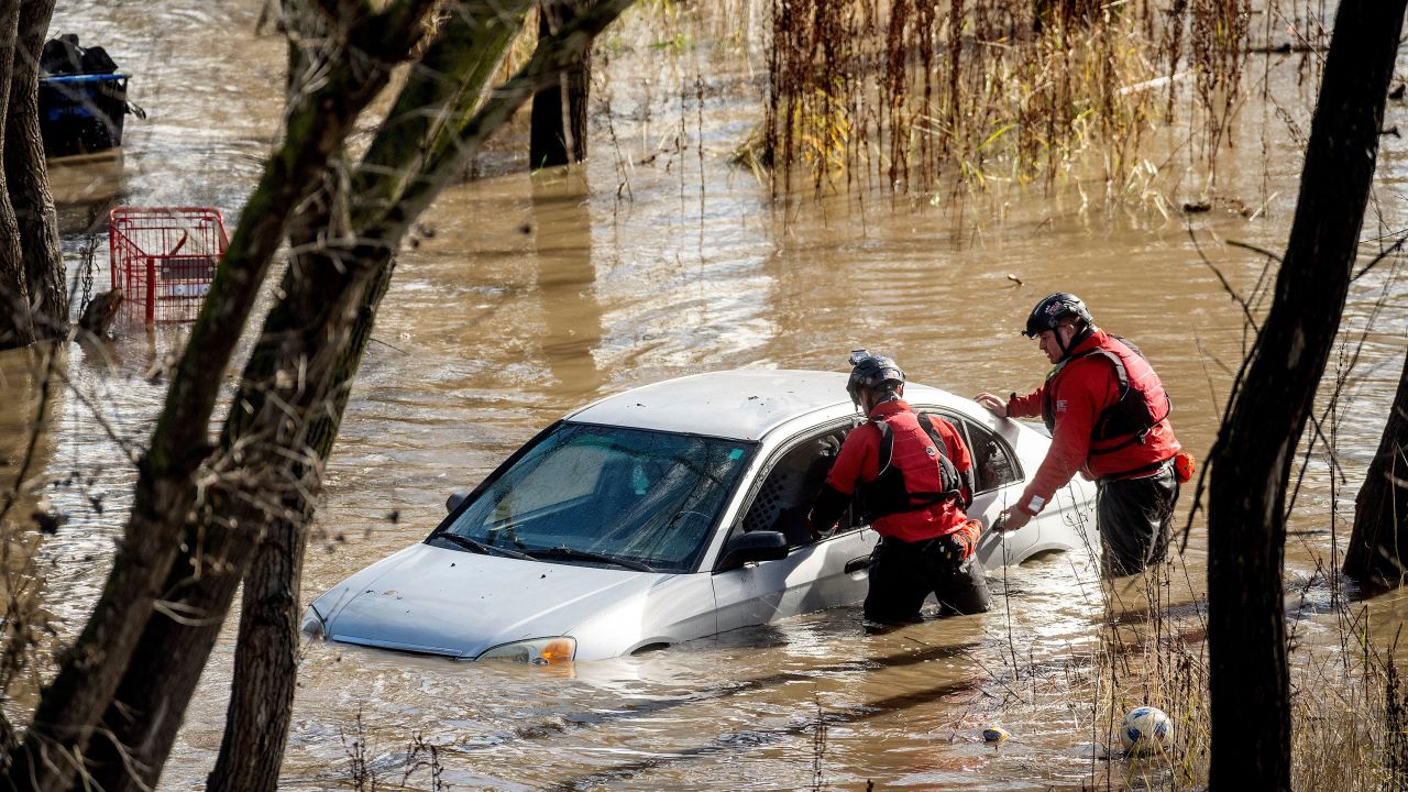 Search and rescue workers investigate a car surrounded by floodwater as heavy rains caused the Guadalupe River to swell, Sunday, Feb. 4, 2024, in San Jose, Calif. The vehicle was uninhabited. (AP Photo/Noah Berger)