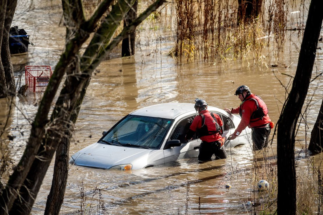 Search and rescue workers investigate a car surrounded by floodwaters in San Jose, California.