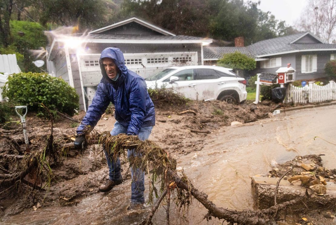Jeffrey Raines clears debris from a mudslide at his parent's home Monday in Los Angeles.