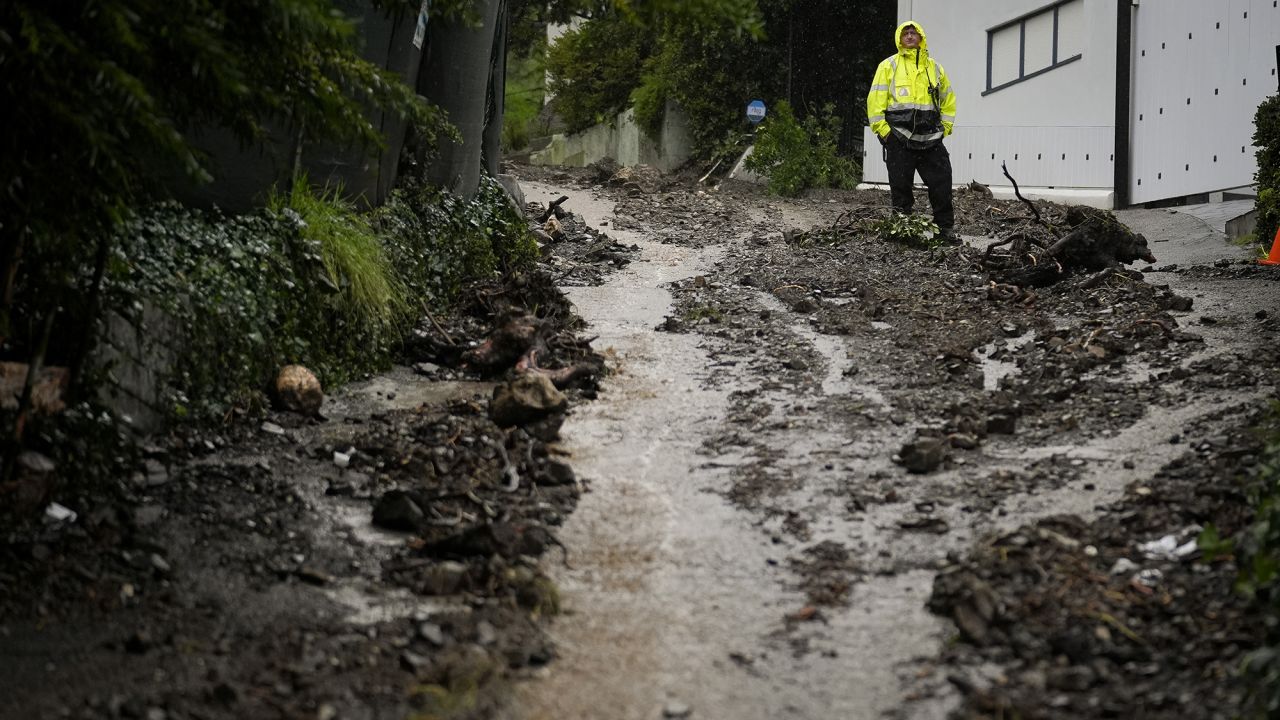 A first responder stands atop a hill in the aftermath of a mudslide, Monday, Feb. 5, 2024, in the Beverly Crest area of Los Angeles.