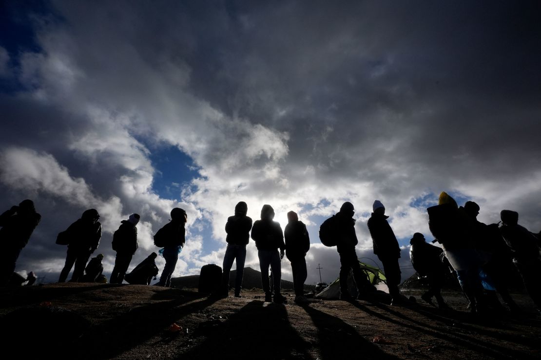Asylum-seeking migrants wait to be processed in a makeshift campsite after crossing the border with Mexico on February 2, 2024, near Jacumba Hot Springs, California.