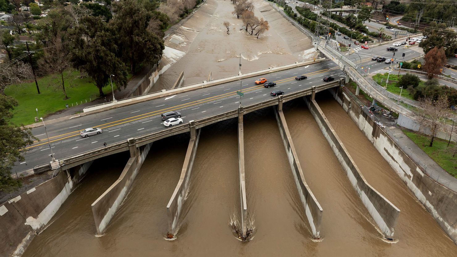 A drone view shows the Los Angeles River full of muddy runoff water from the atmospheric river rain storm on February 6.
