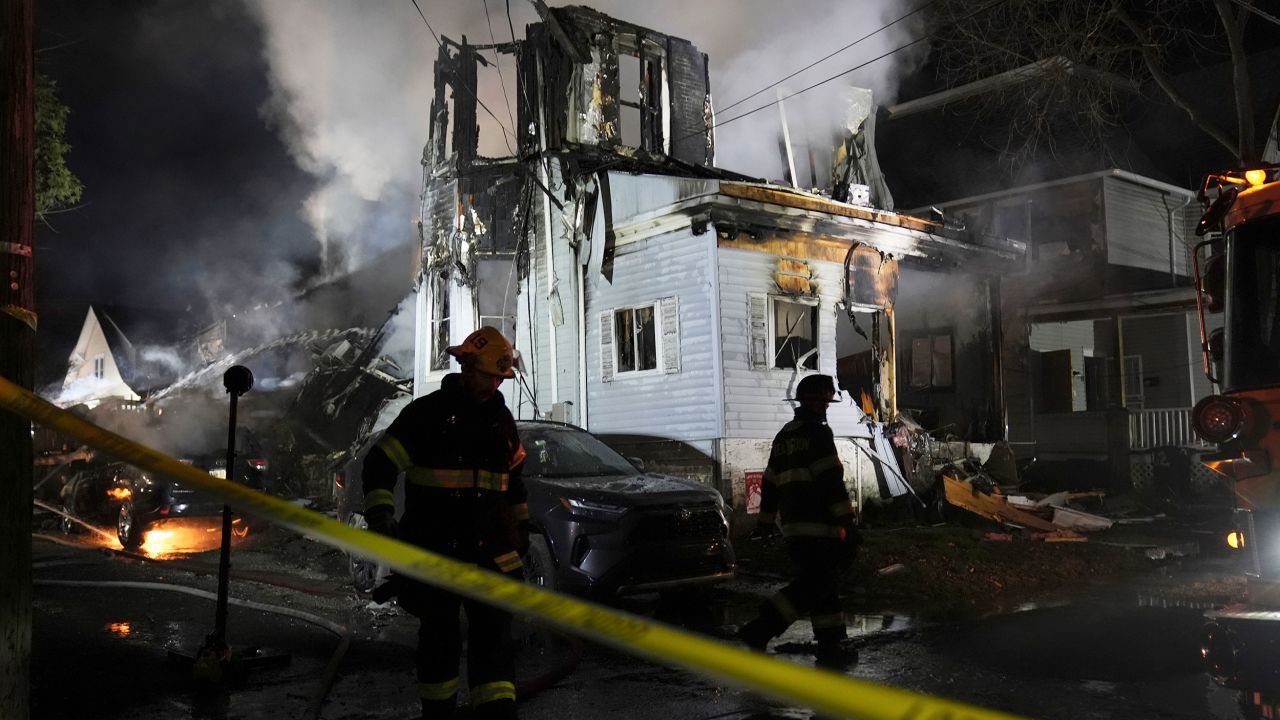 Firefighters work at the scene where two police officers were injured while responding to reported standoff in East Lansdowne, Pa., on Wednesday, Feb. 7, 2024. (AP Photo/Matt Rourke)