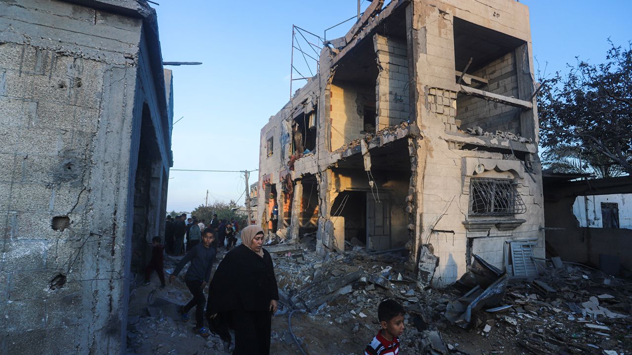 Palestinians walk by a residential building destroyed in an Israeli strike in Rafah, Gaza Strip, Sunday, Feb. 11, 2024.