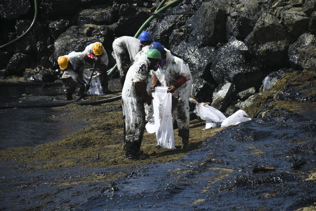 Workers clean up an oil spill on Rockly Bay beach in Scarborough, Trinidad and Tobago, on February 10, 2024. The origin of the ship that caused the spill is not yet known.