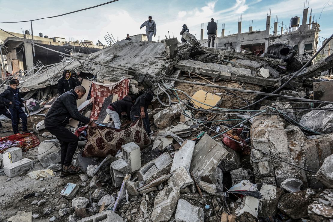 Palestinians inspect damaged buildings after Israeli airstrikes on Rafah, southern Gaza, on February 12, 2024.