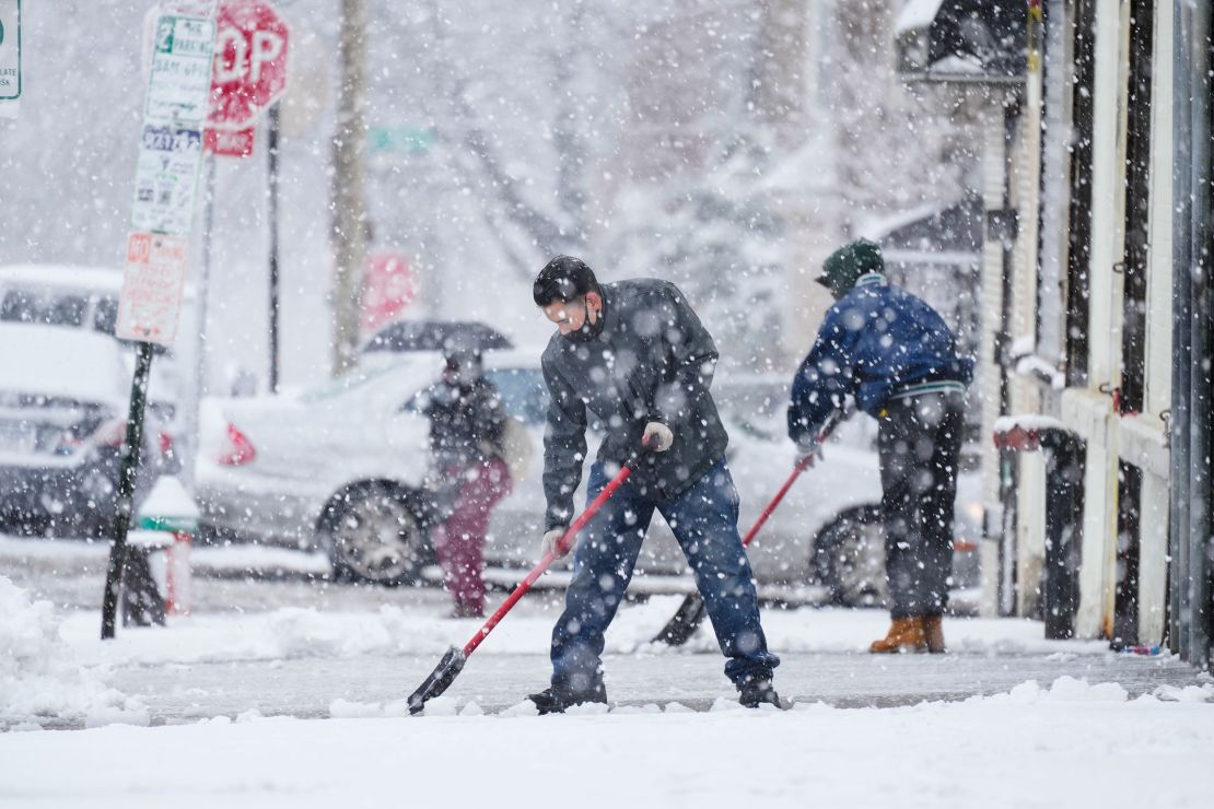 People clear a sidewalk during a winter snow storm in Philadelphia.
