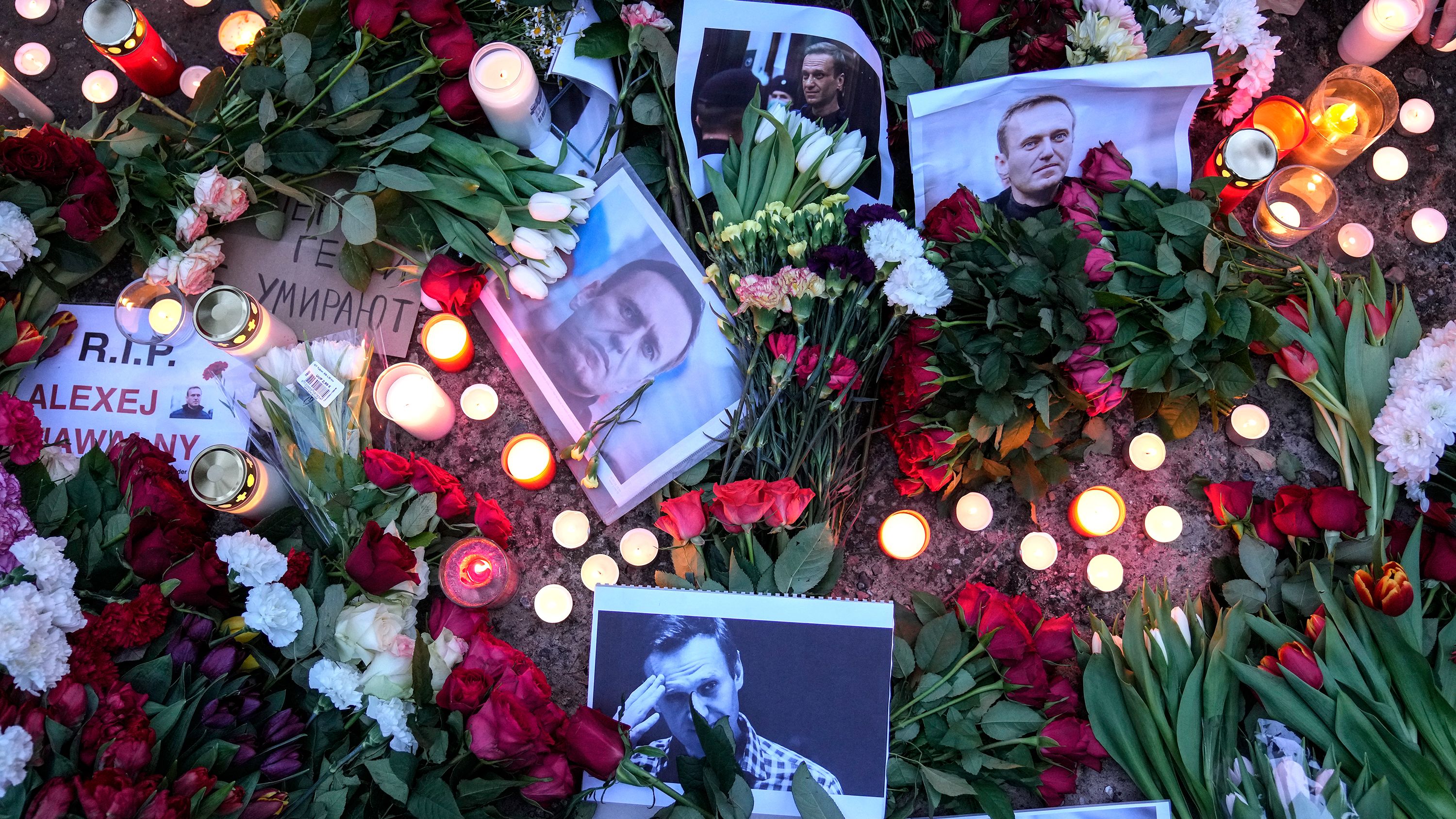 Portraits of jailed Russian opposition leader Alexey Navalny, flowers and candles are laid on a ground as people protest in front of the Russian embassy in Berlin on Friday.
