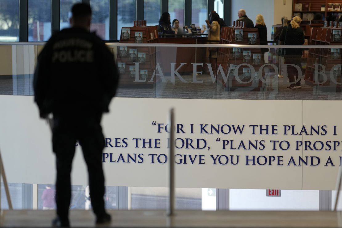 Un policier se tient en haut des marches de l'église de Lakewood, le dimanche 18 février 2024, à Houston.  Le pasteur Joel Osteen a accueilli les fidèles pour la première fois depuis qu'une femme avec un fusil de type AR a ouvert le feu entre les services dans sa méga-église du Texas dimanche dernier.