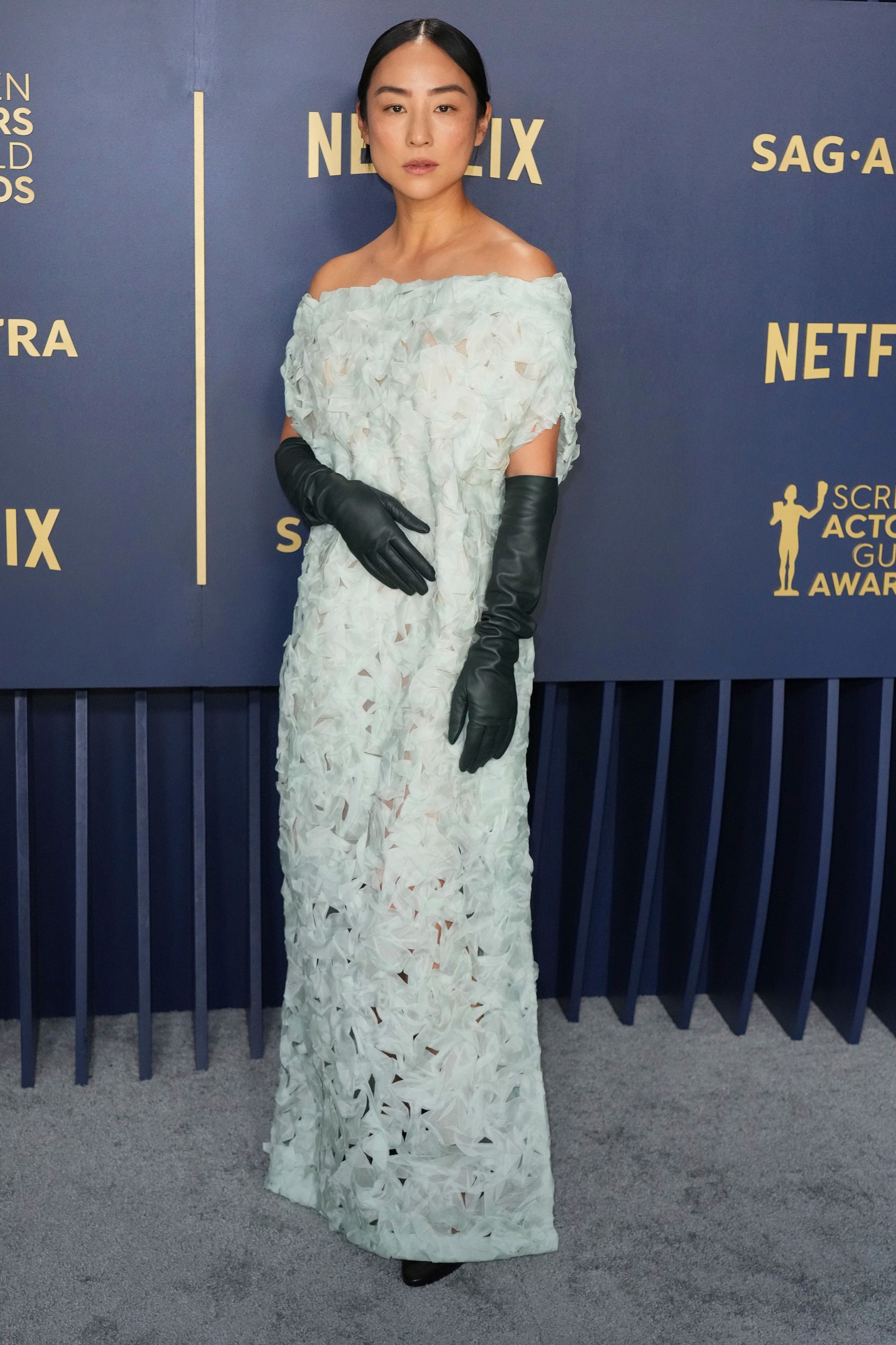 Greta Lee in a delicate sheath dress (and leather gloves) from The Row's 2024 Resort collection..