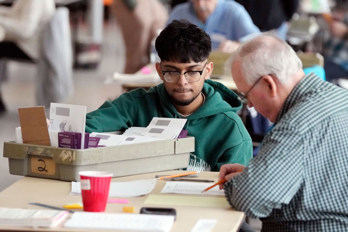 Election workers in Warren, Michigan, sort through absentee ballots on February 27, 2024.